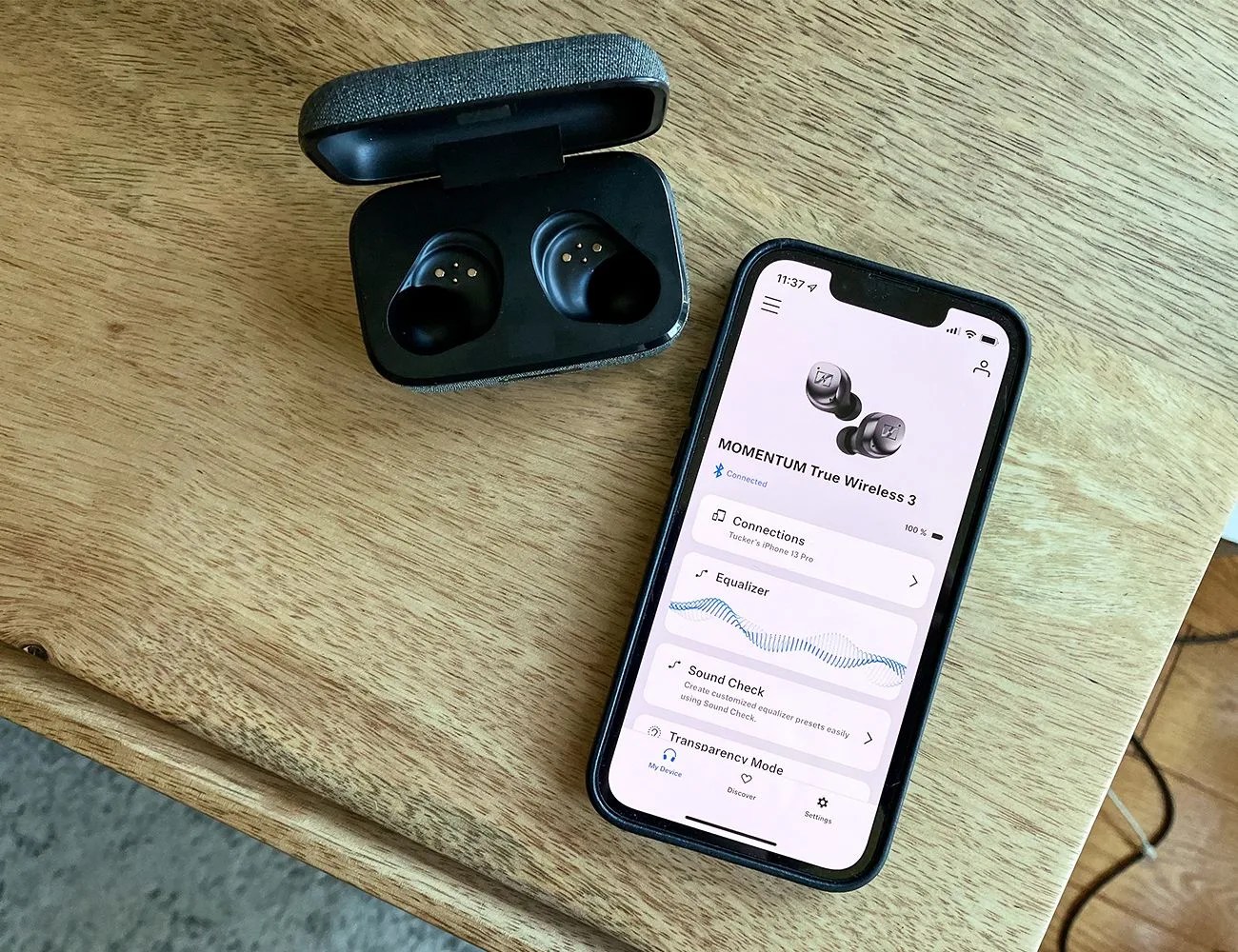 sennheiser smart control app on phone next to an earbud case