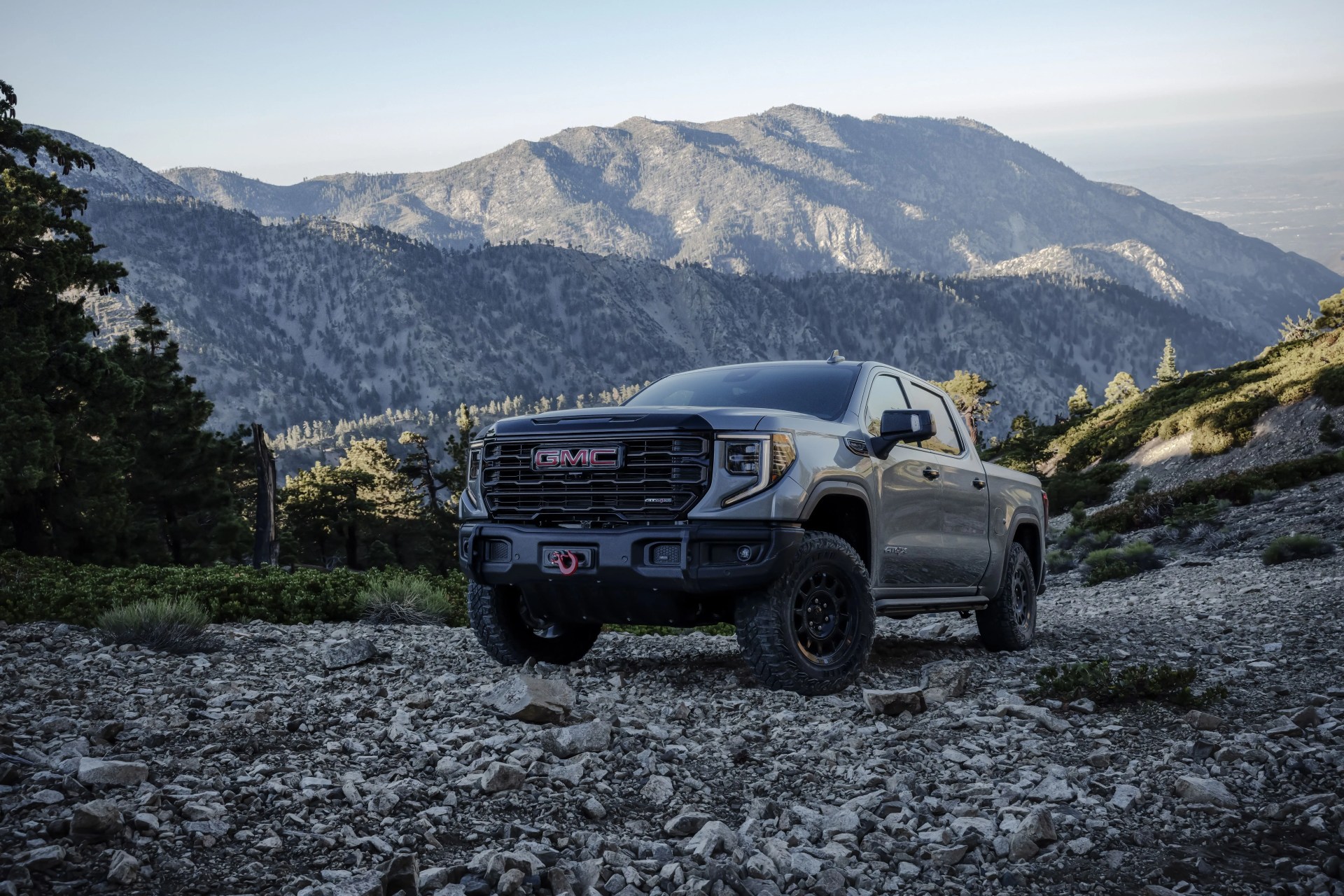the 2023 gmc sierra 1500 at4x aev edition driving on a rocky hillside the at4x aev edition delivers extreme off road capability without compromising on road comfort