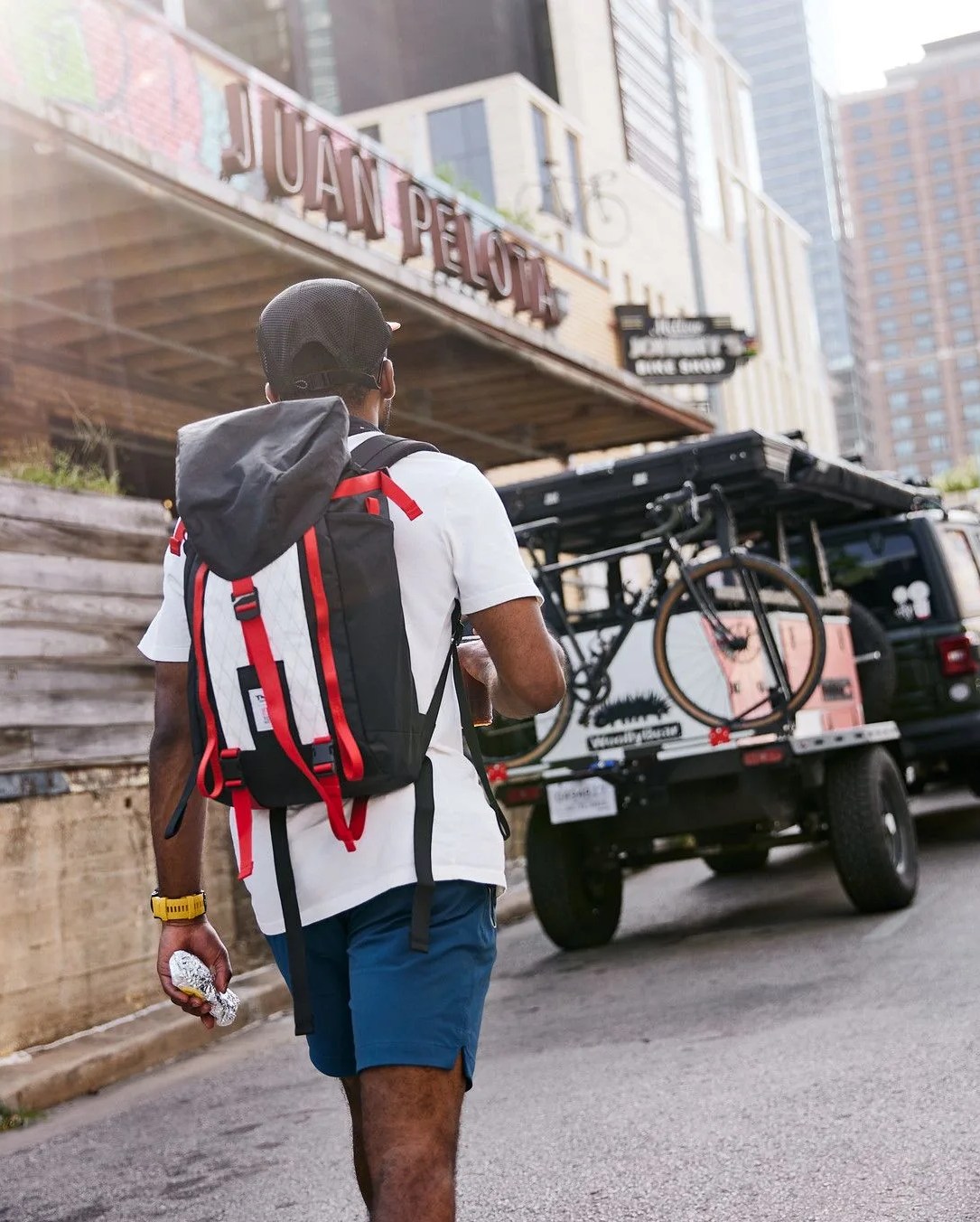 man walking towards taxa outdoors x topo designs limited edition kit and basecamp trailer