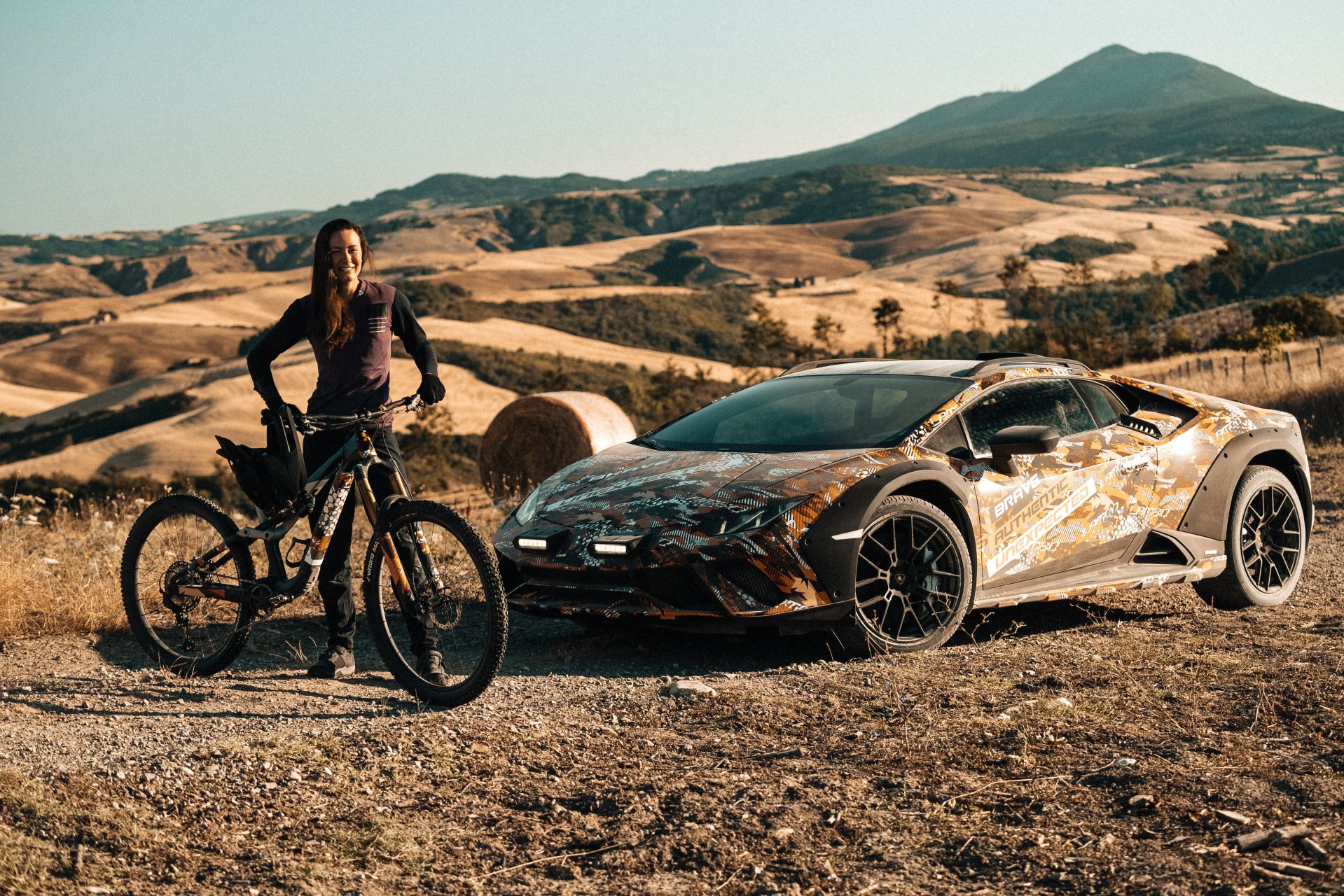 lamborghini huracan sterrato prototype photographed in the desert next to a mountain biker