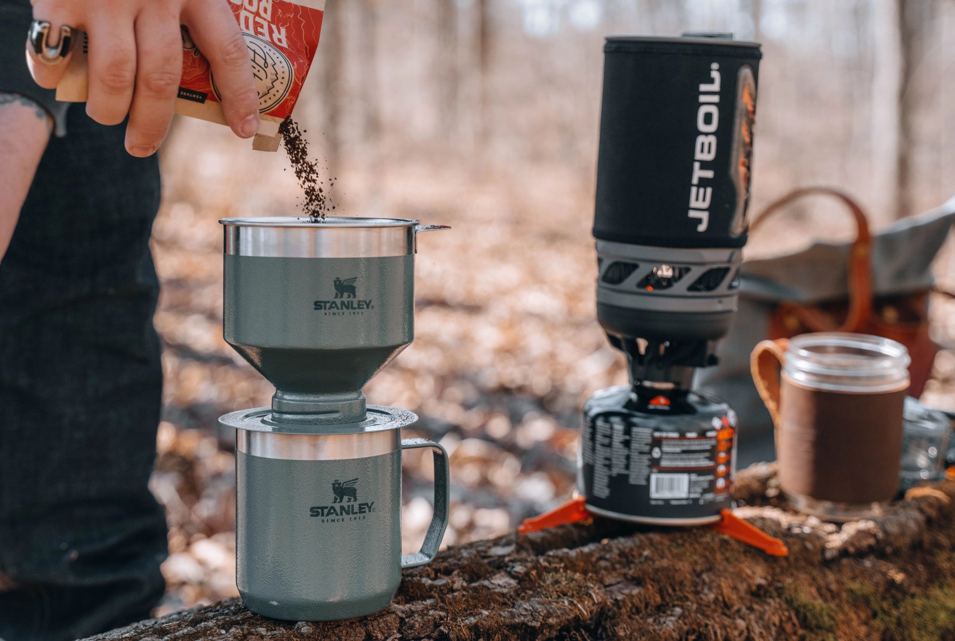 person pouring hikers brew venture pouch coffee into stanley brewing cup