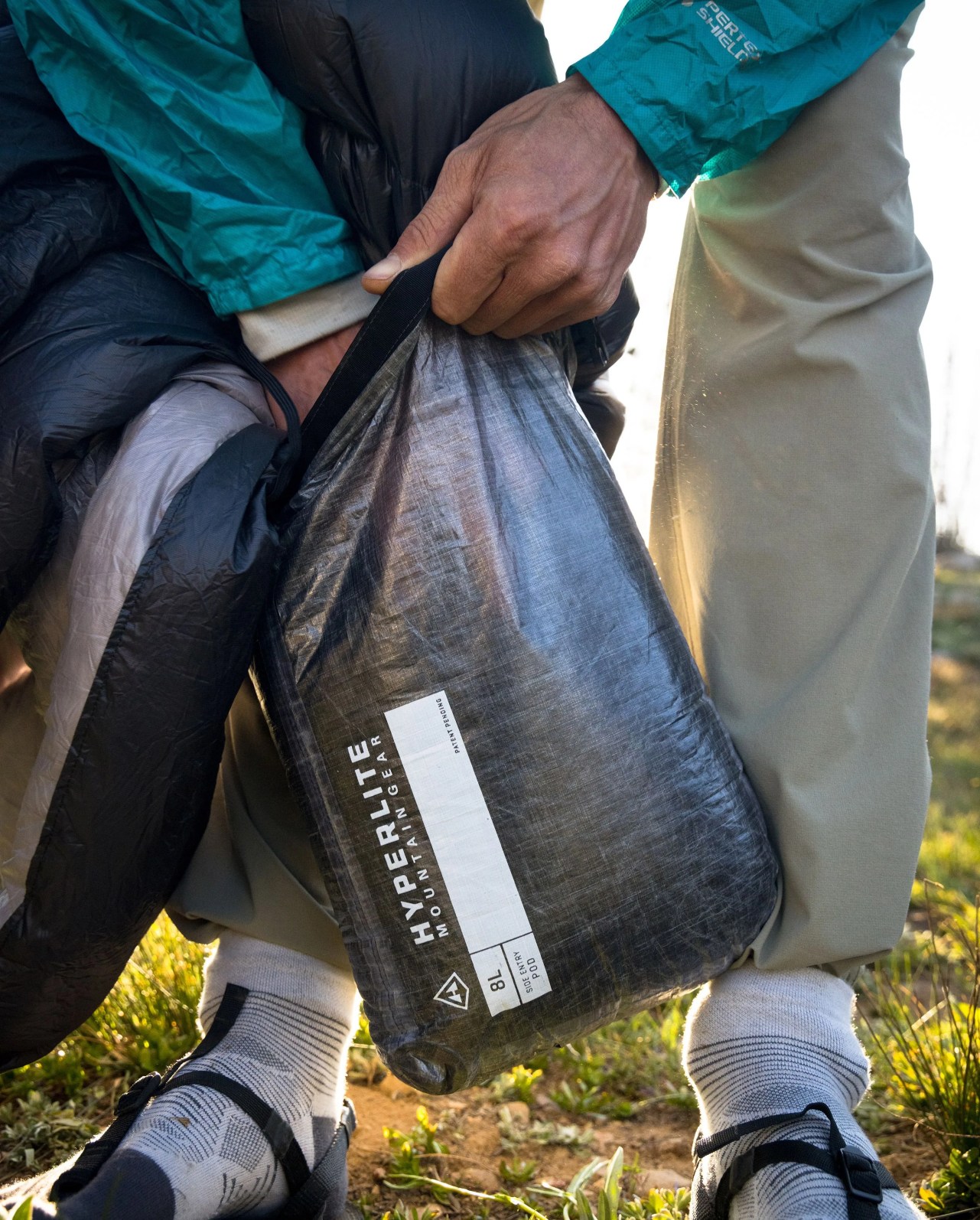 sponsored product man stuffing hyperlite mountain gear quilt back into bag