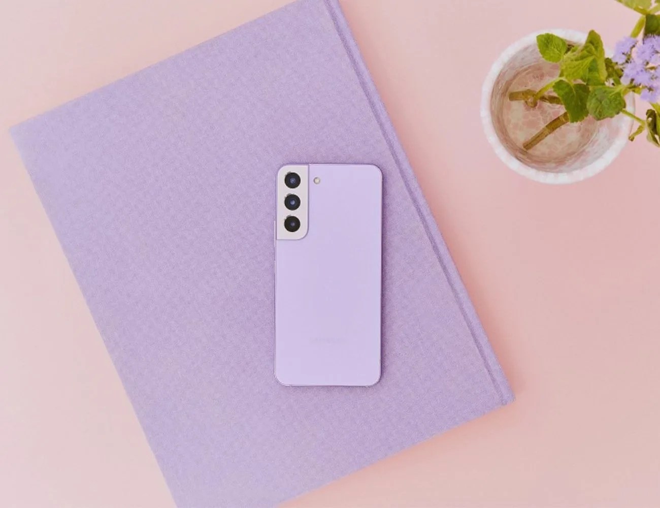 samsung galaxy s22 in the new bora purple color laying on a book