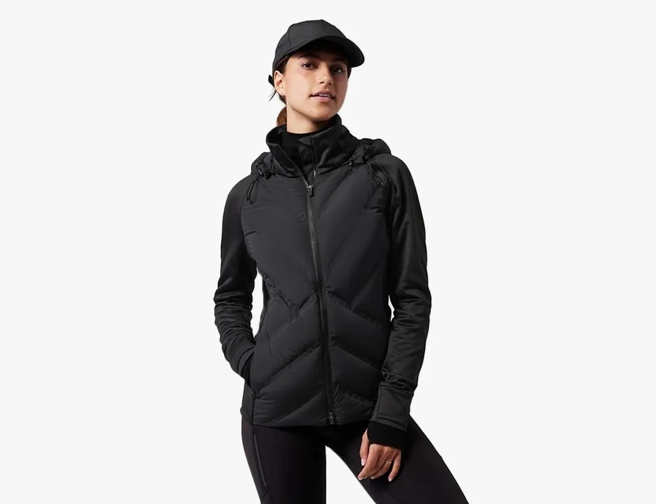 woman wearing a black Athleta Inlet Jacket with a black hat and leggings