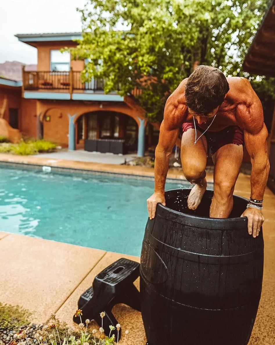 man climbing into ice barrel