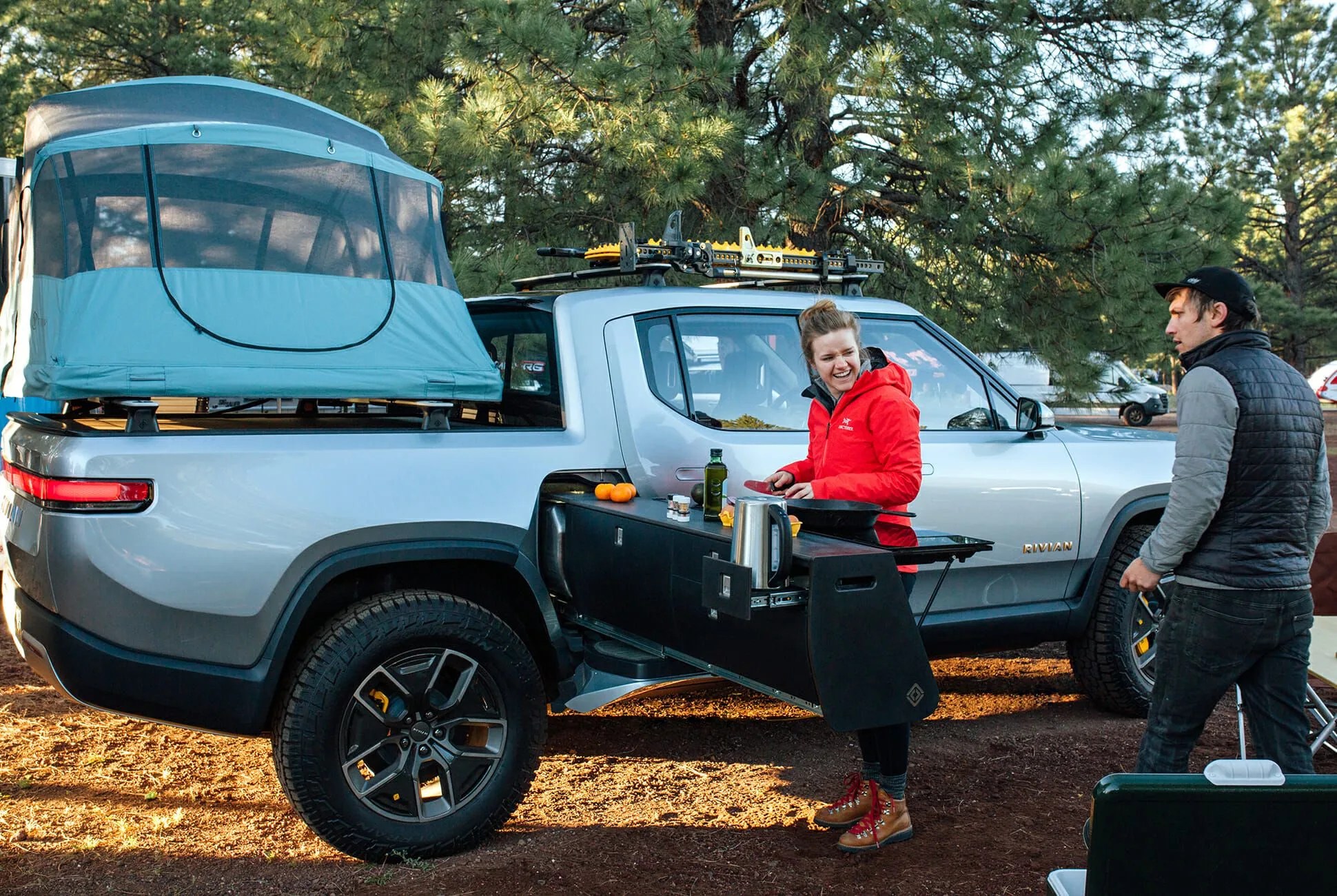 rivian r1t camp kitchen in use with a tent on top of the bed