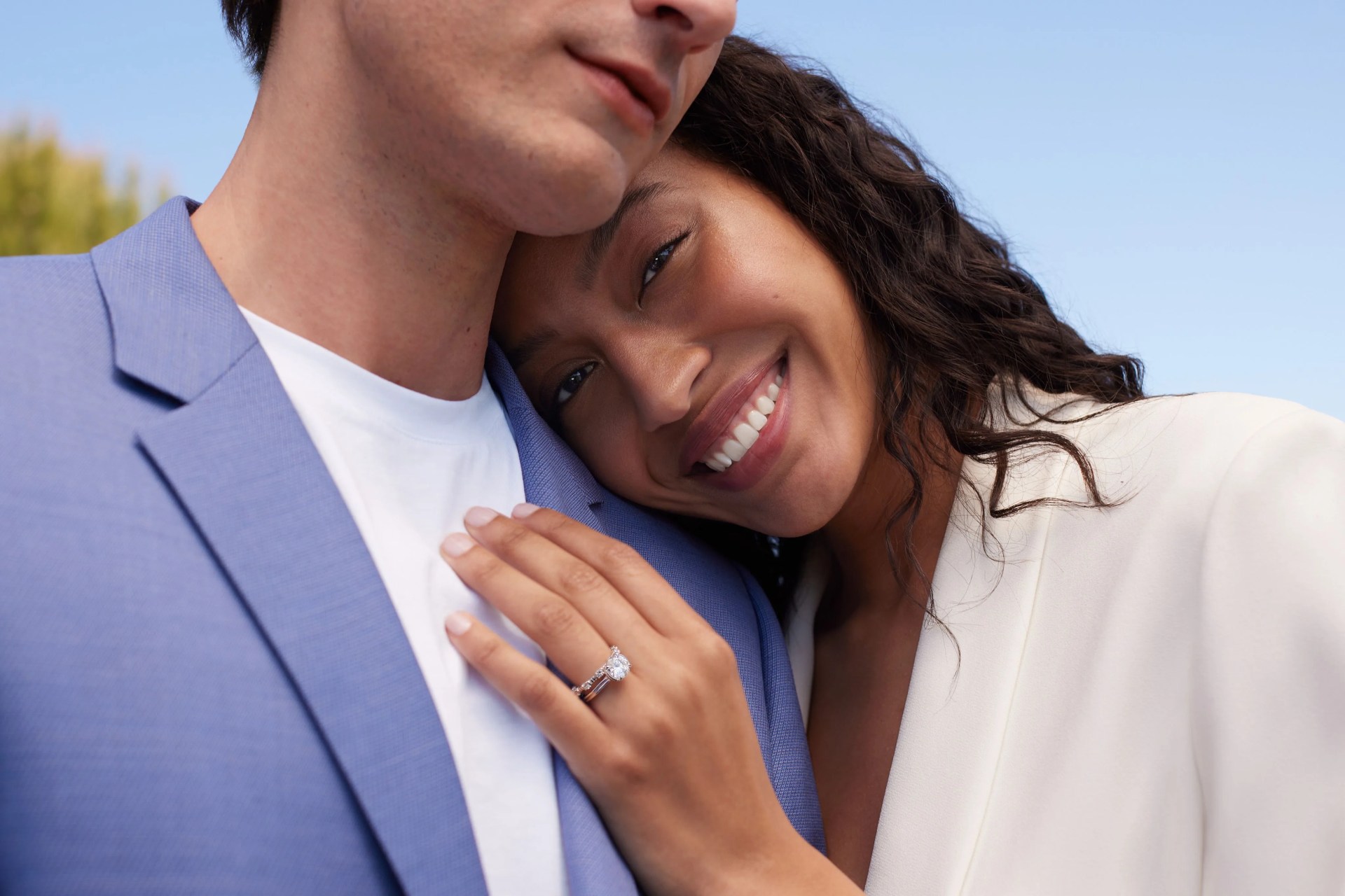 woman leaning into man wearing engagement ring from brilliant earth