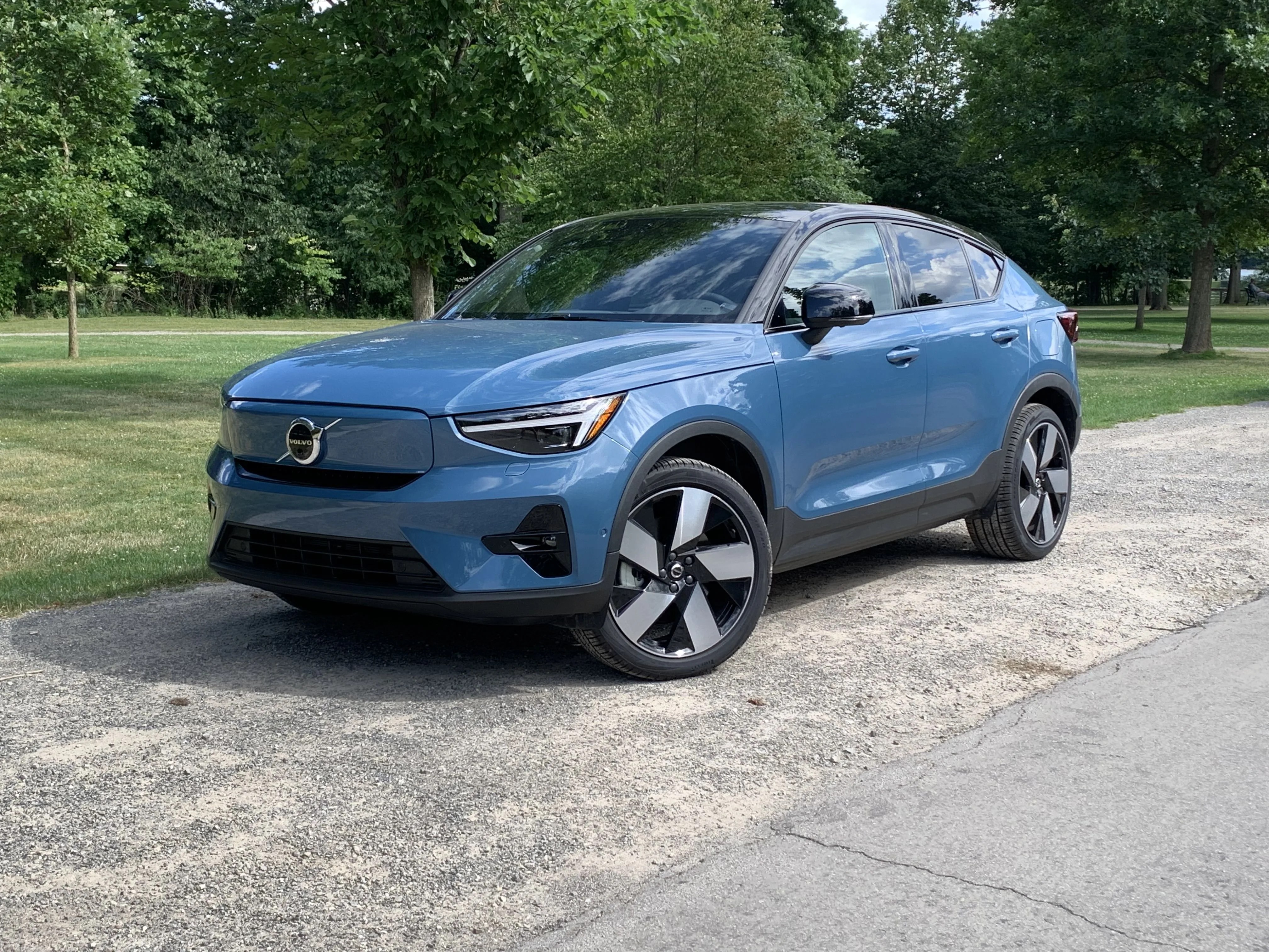 volvo c40 recharge parked in gravel next to a park