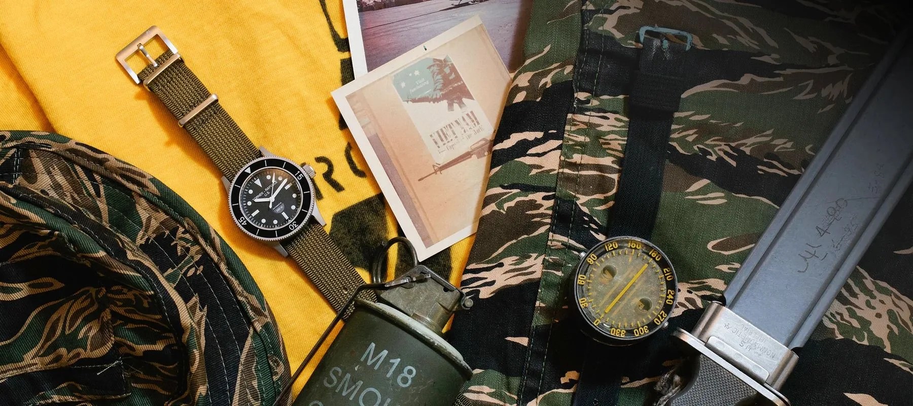 flat lay of a watch surrounded by camo and military gear