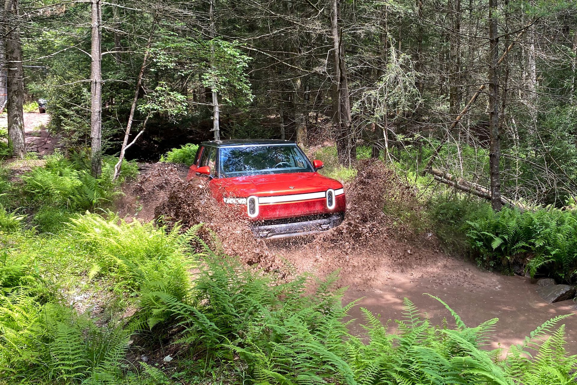 rivian r1s driving through mud