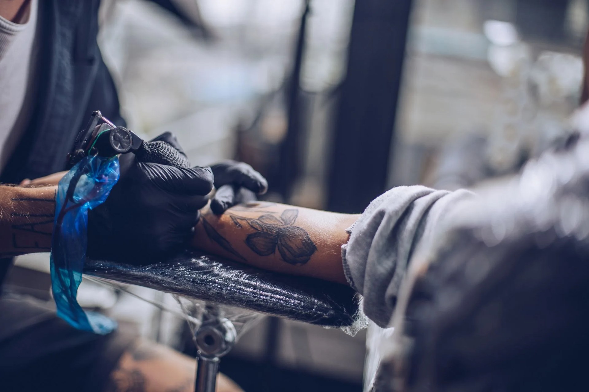 artist drawing tattoo on a hand