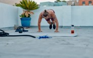 full length shot of a handsome young man doing burpees during a workout on the rooftop