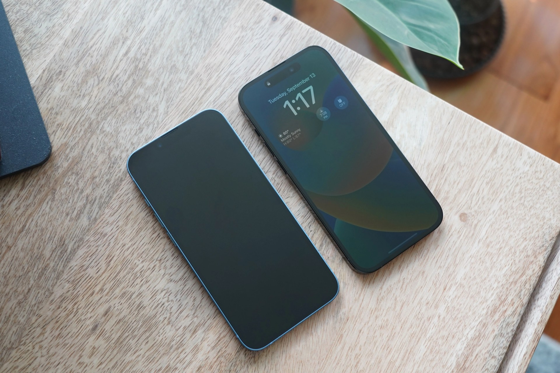 two iphones on a desk, one showing the always on display