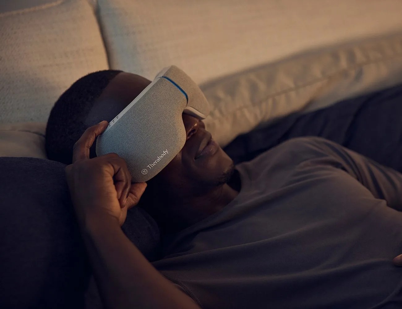 man laying with a therabody mask on his face