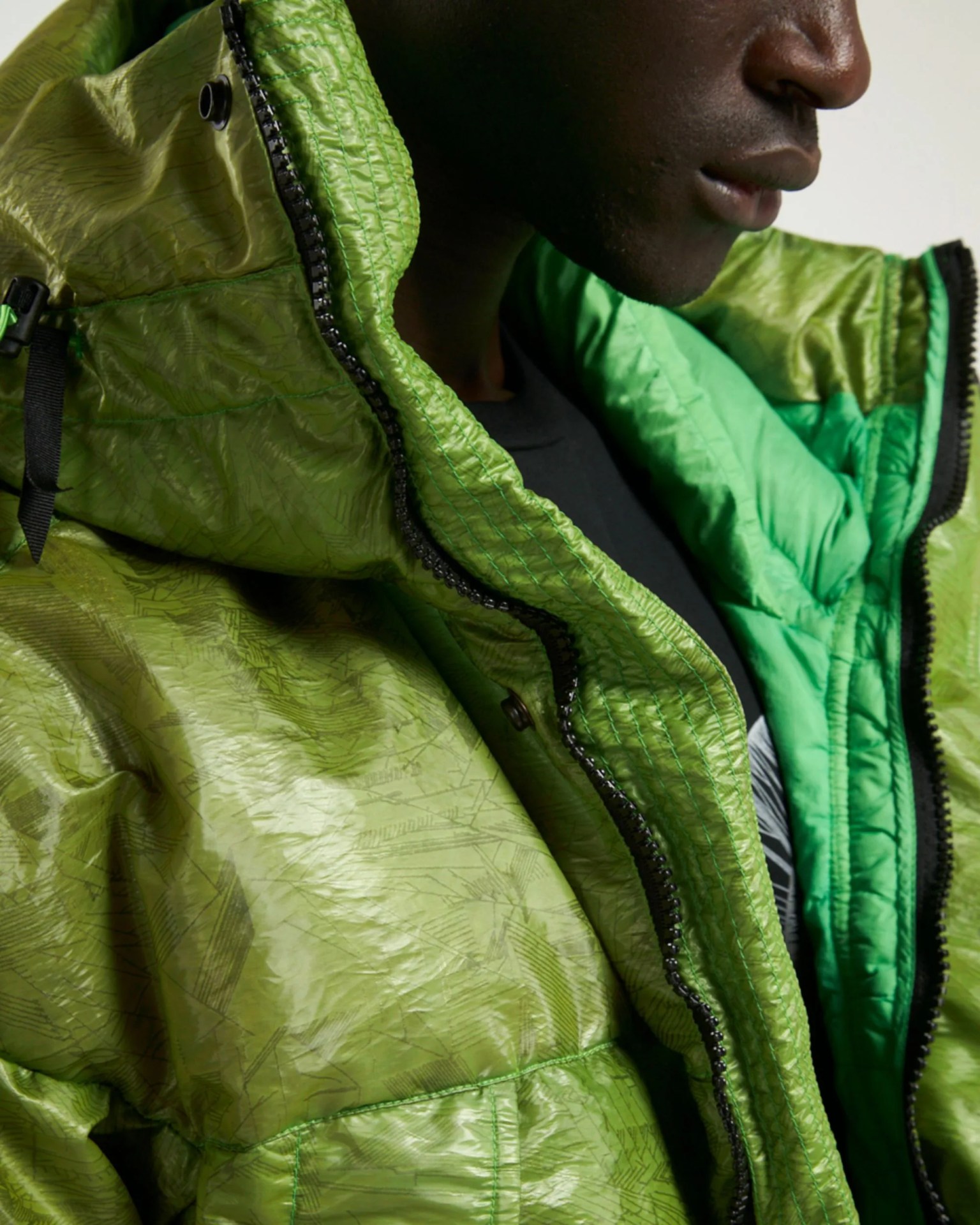 a man wearing the bright green, water repellant leaf down jkt