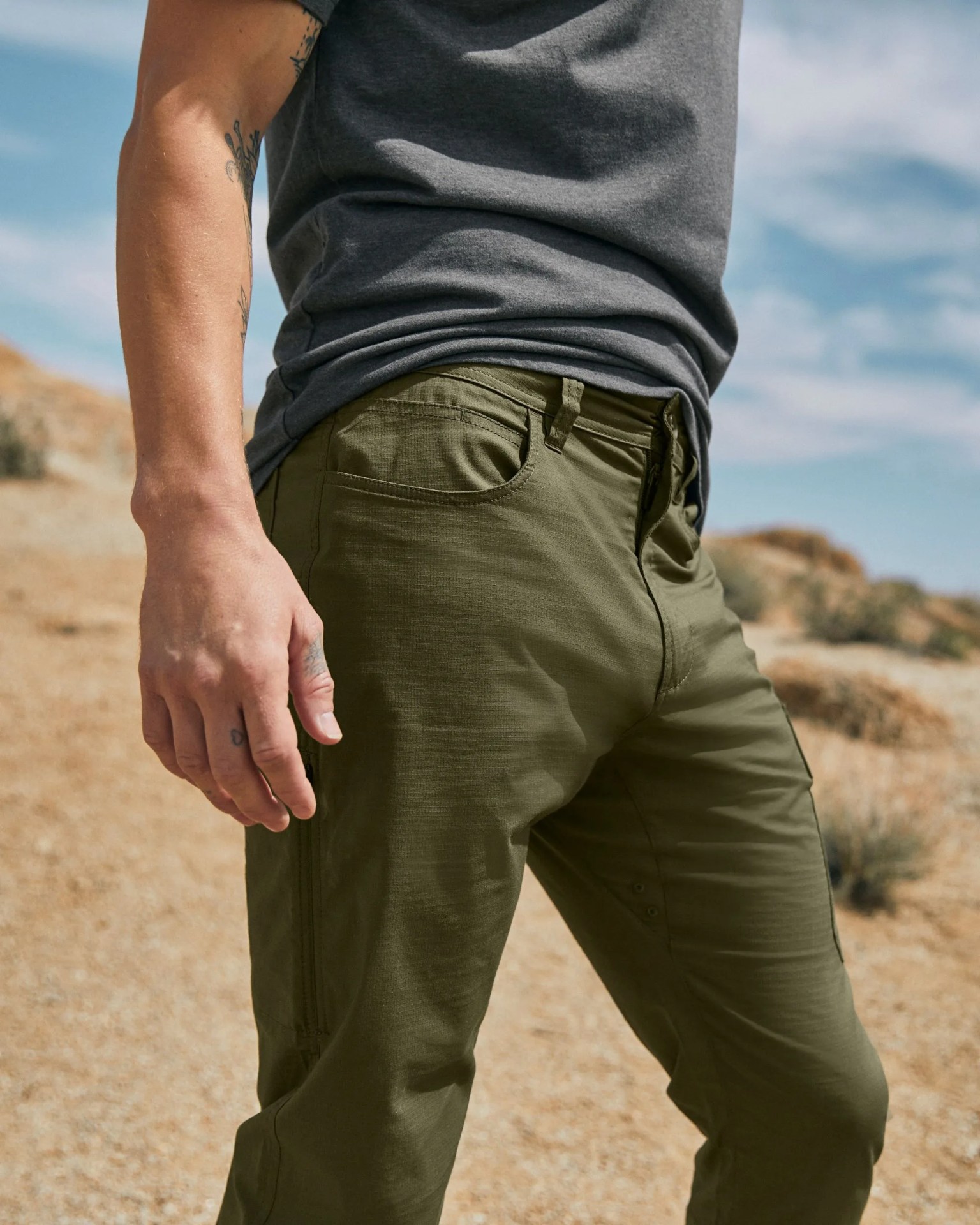 a man wearing green prana pants in a desert setting