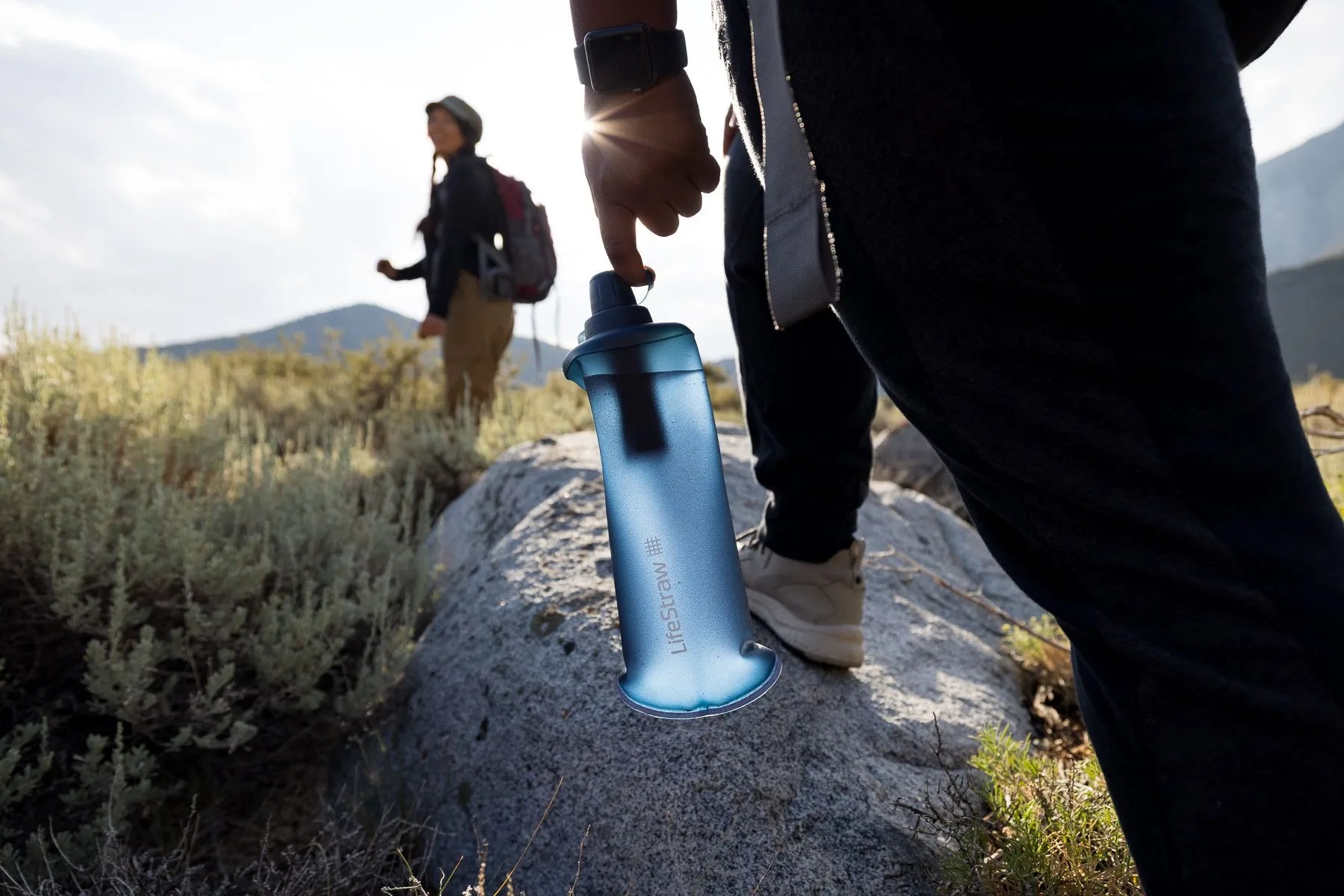 two people hiking holding lifestraw squeeze filters