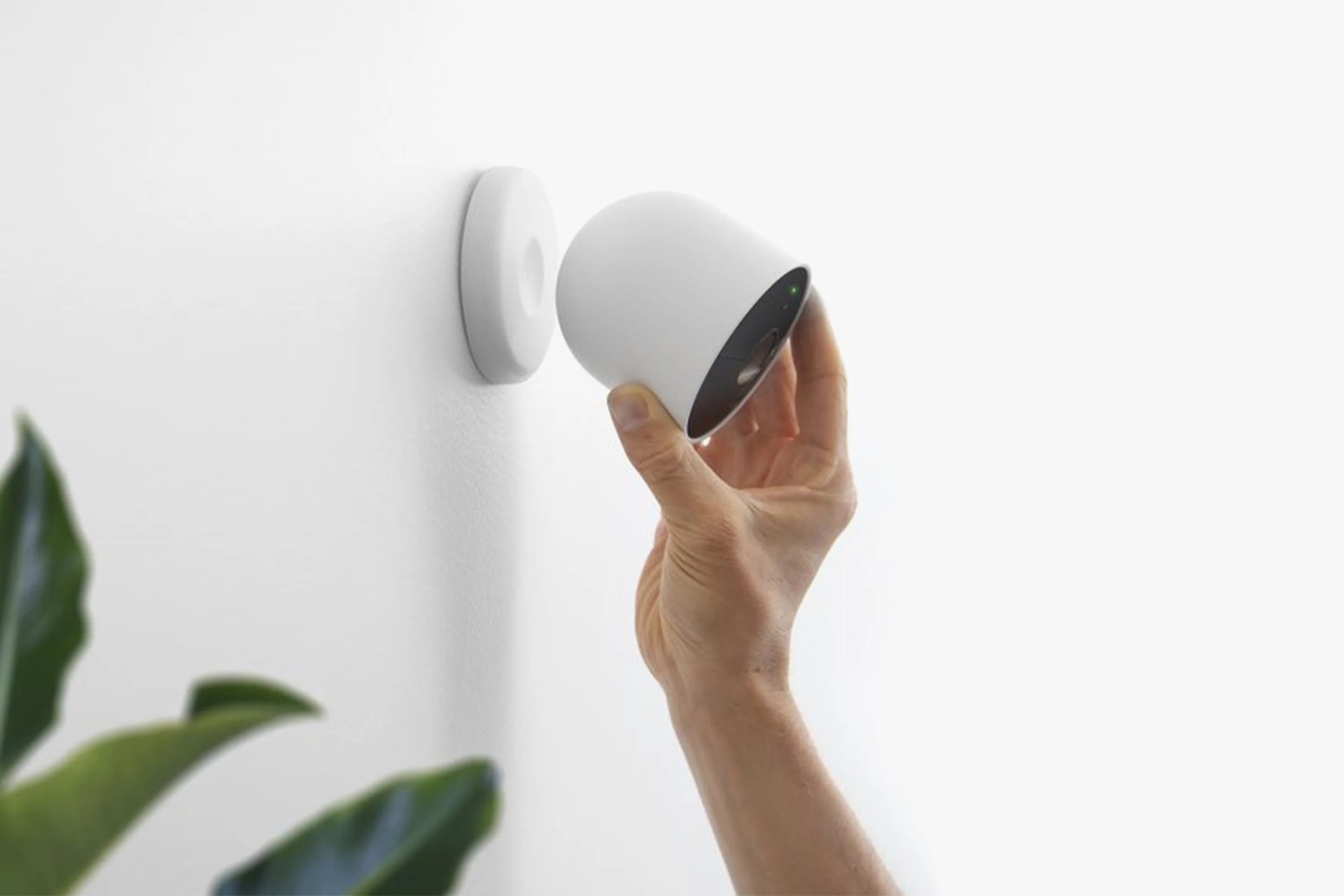 someone fixing a google nest cam on a wall