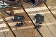 two pairs of wireless ear buds next to running shoes