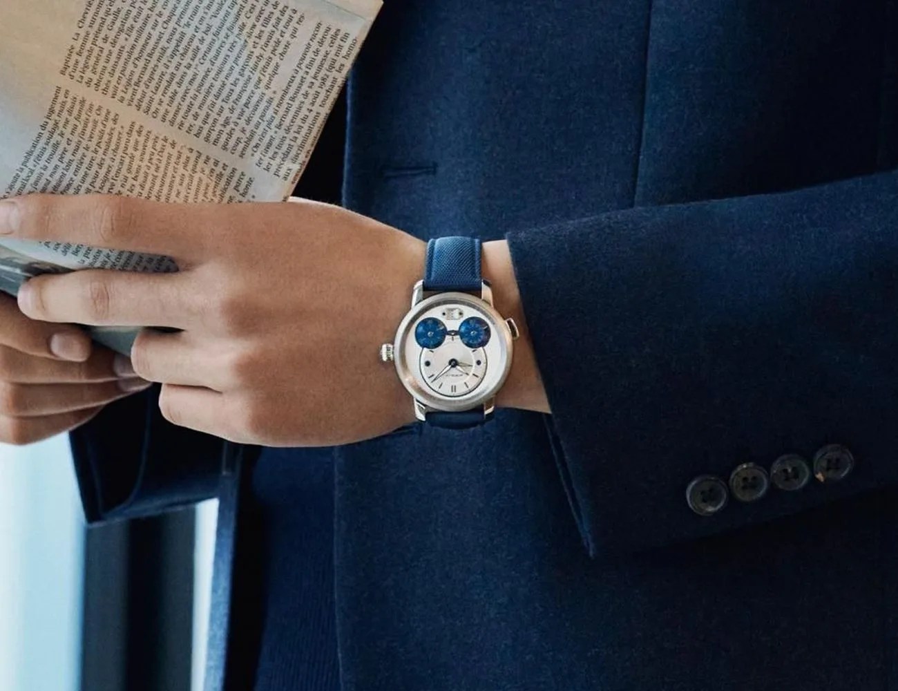 man wearing a montblanc watch while reading a newspaper