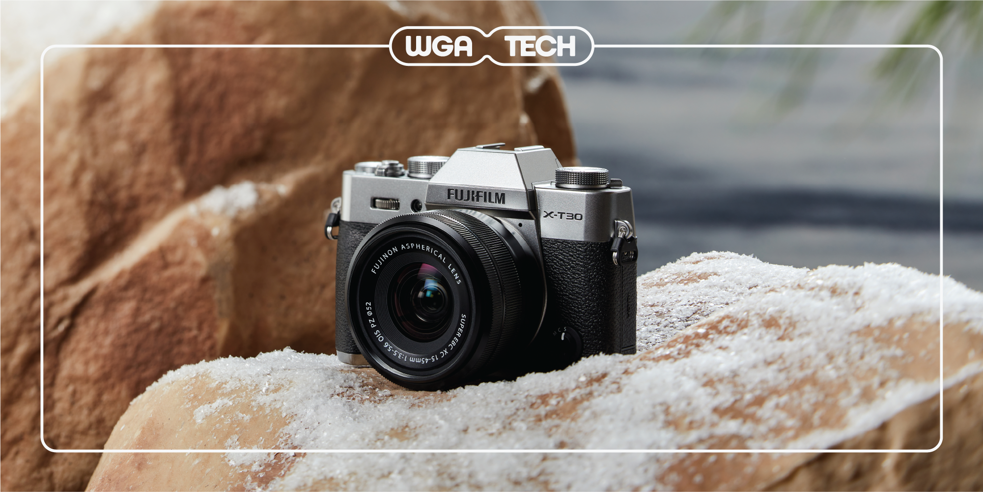 a fujifilm camera sitting on snowy rocks