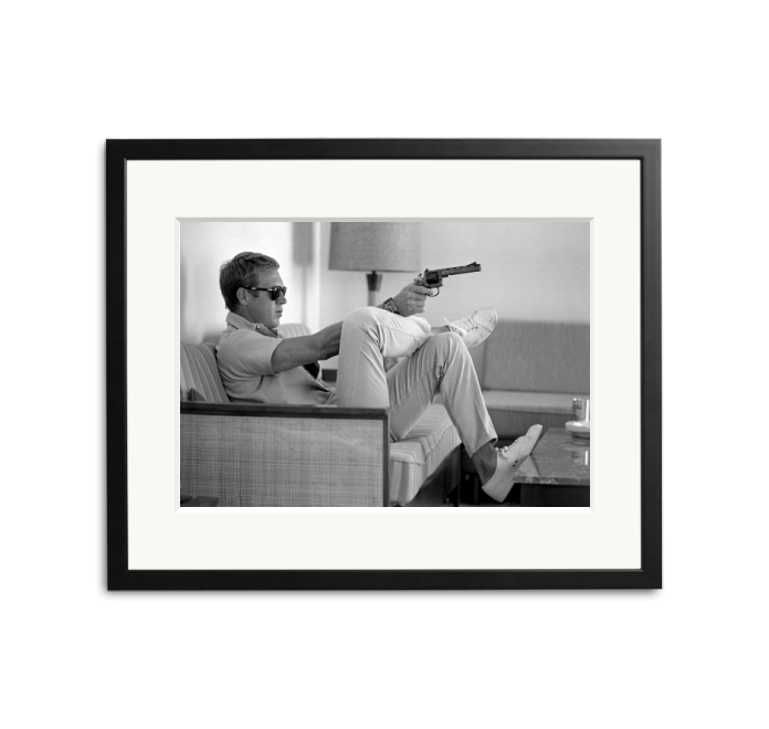 Steve McQueen aims a pistol