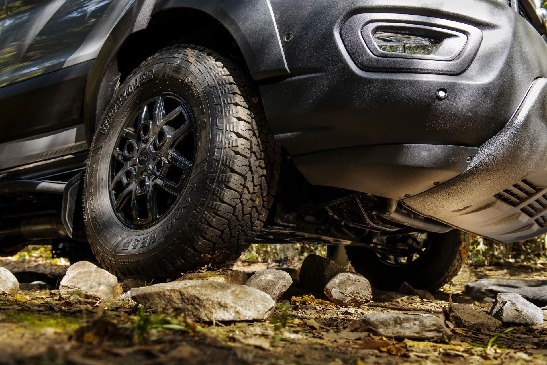 ford transit trail front wheel perched on a rock