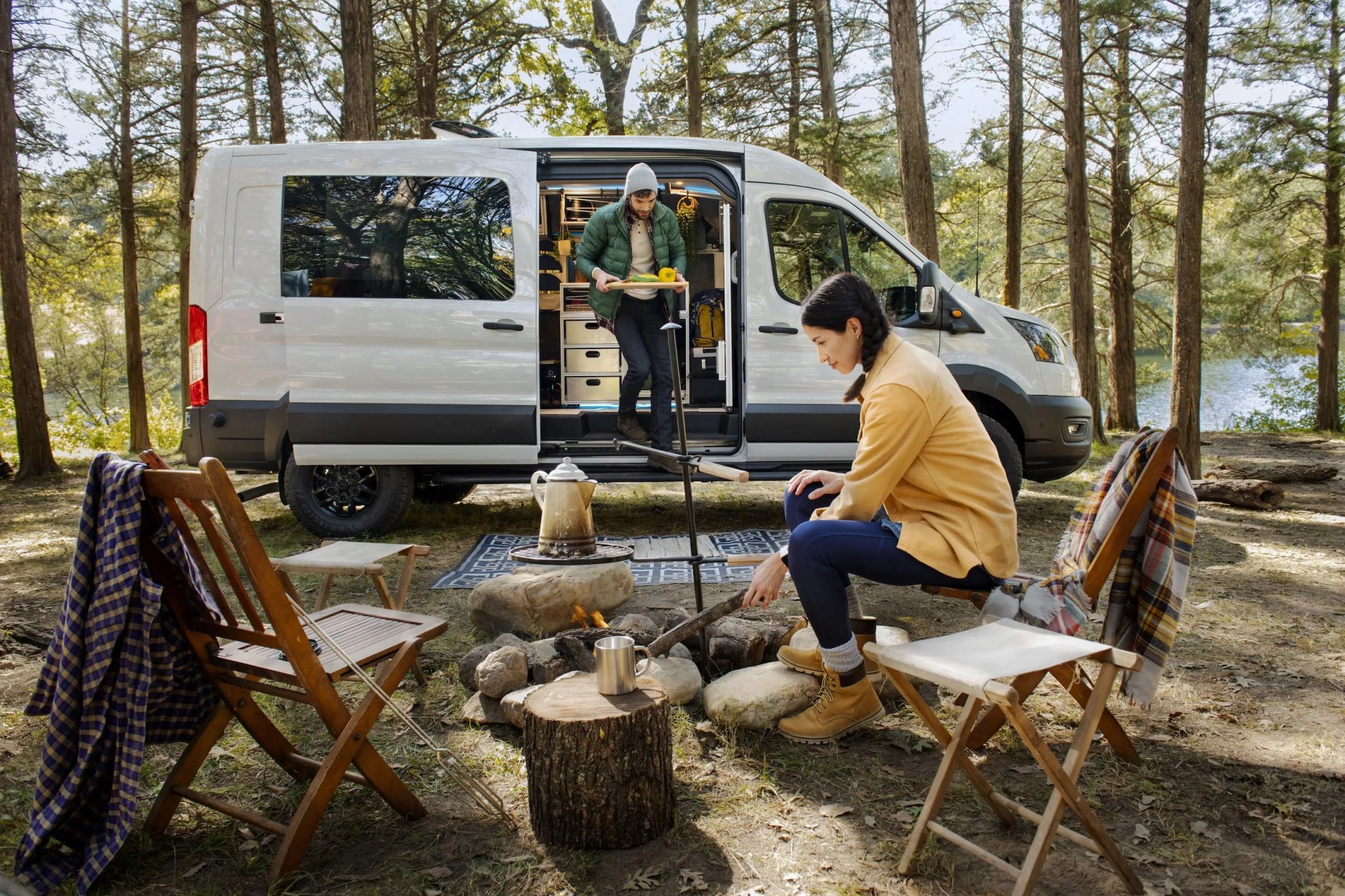 2023 ford transit trail parked in the woods with an outdoor campsite set up