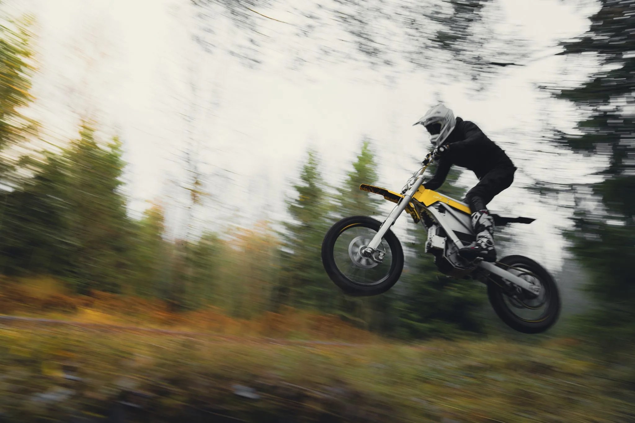 rider jumping a cake bukk off road motorcycle in the woods