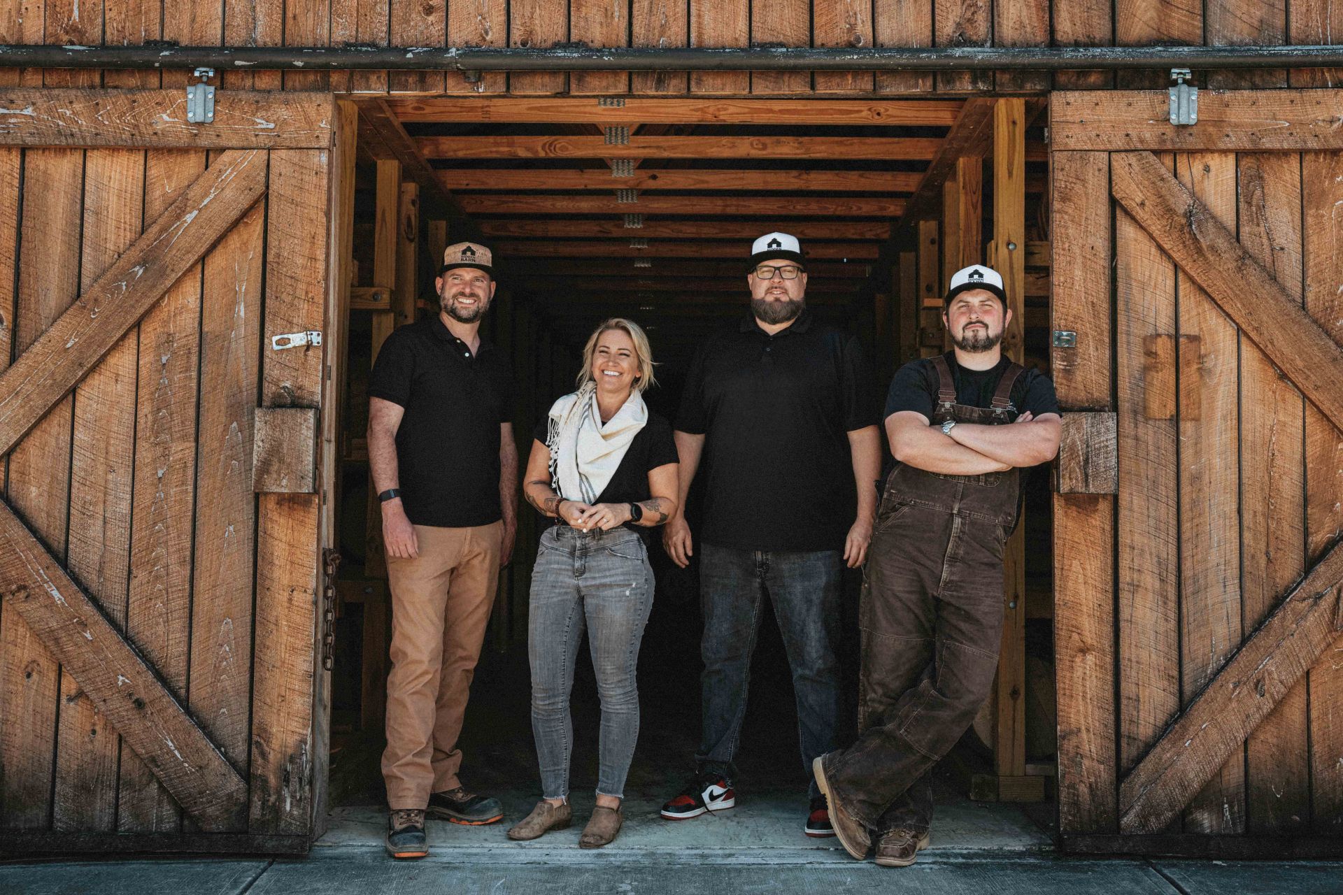 hidden barn whiskey distillers in front of barn