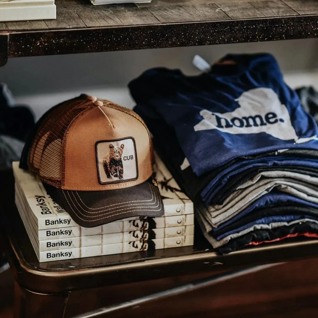 hamilton and adam store with bear cub hat, banksy book and home blue tees