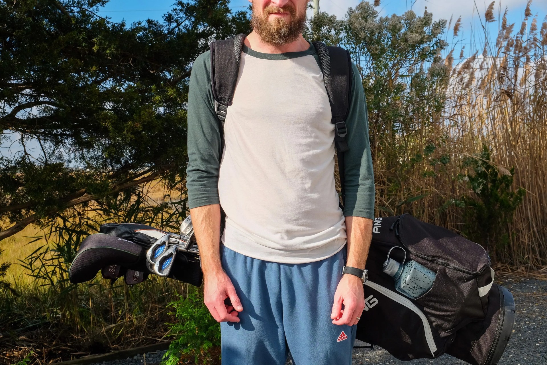 a man wearing a ping hoofer stand golf bag