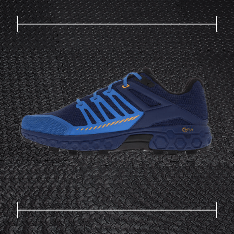 a blue and black innov fitness shoe with orange accents laid over top a photo of black rubber gym flooring