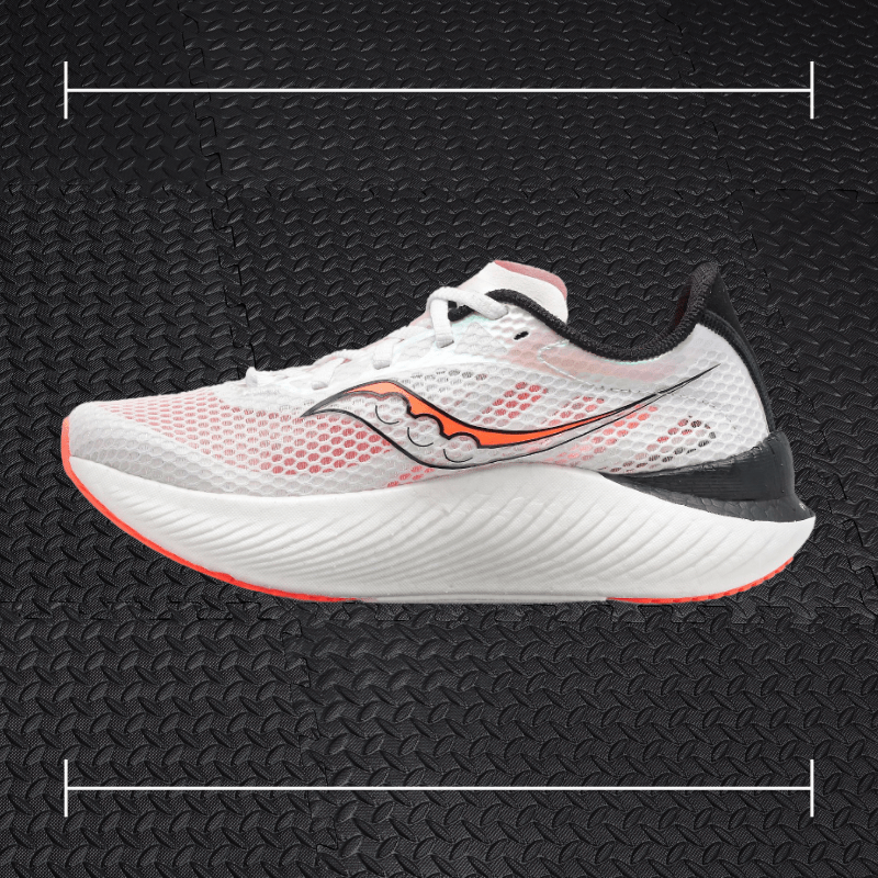 a white saucony fitness shoe with orange and black accents laid over top a photo of black rubber gym flooring