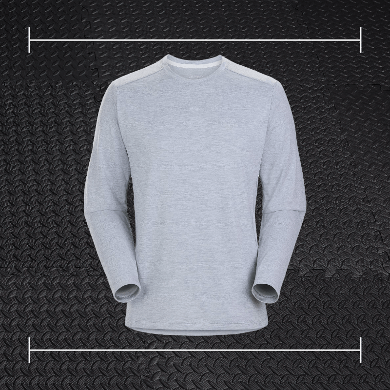 an grey arcteryx long sleeve shirt laid on top a photo of black rubber gym flooring