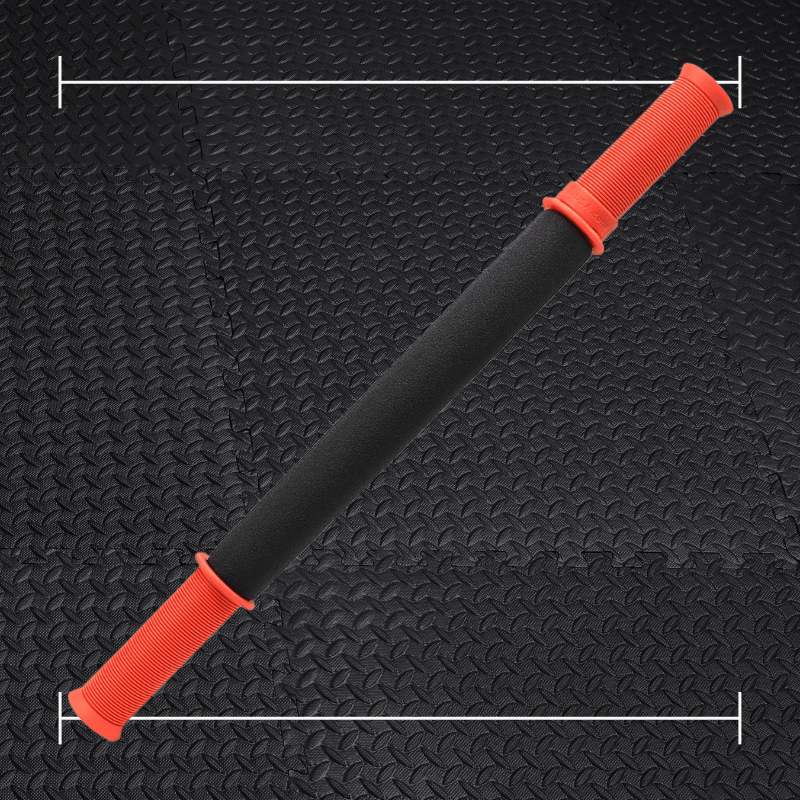 black tiger tail massage stick with red accents laid over top a black rubber gym flooring