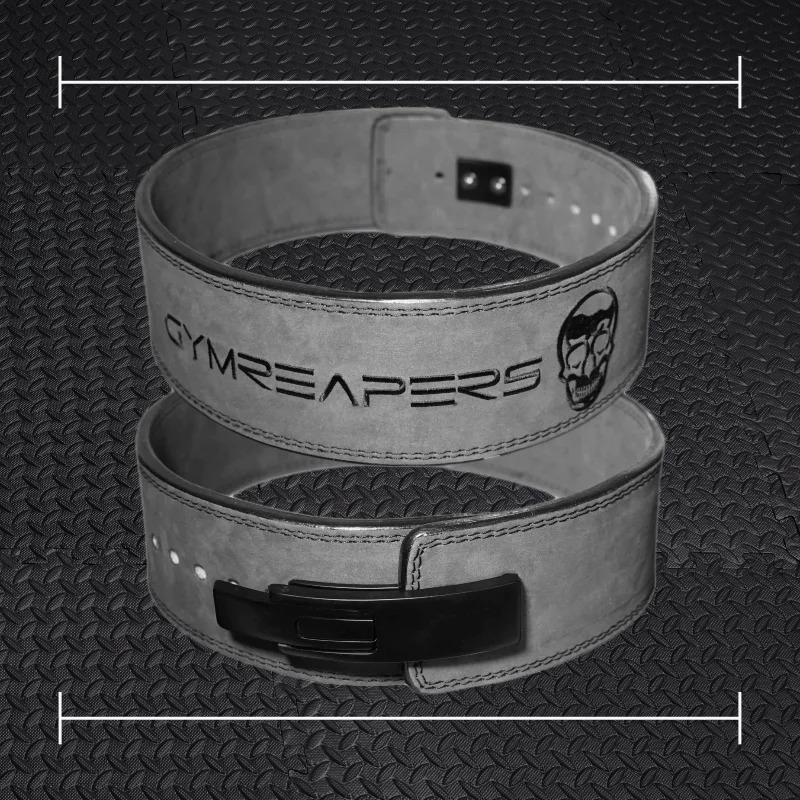 a black gym reapers belt laid over top a photo of black rubber gym flooring