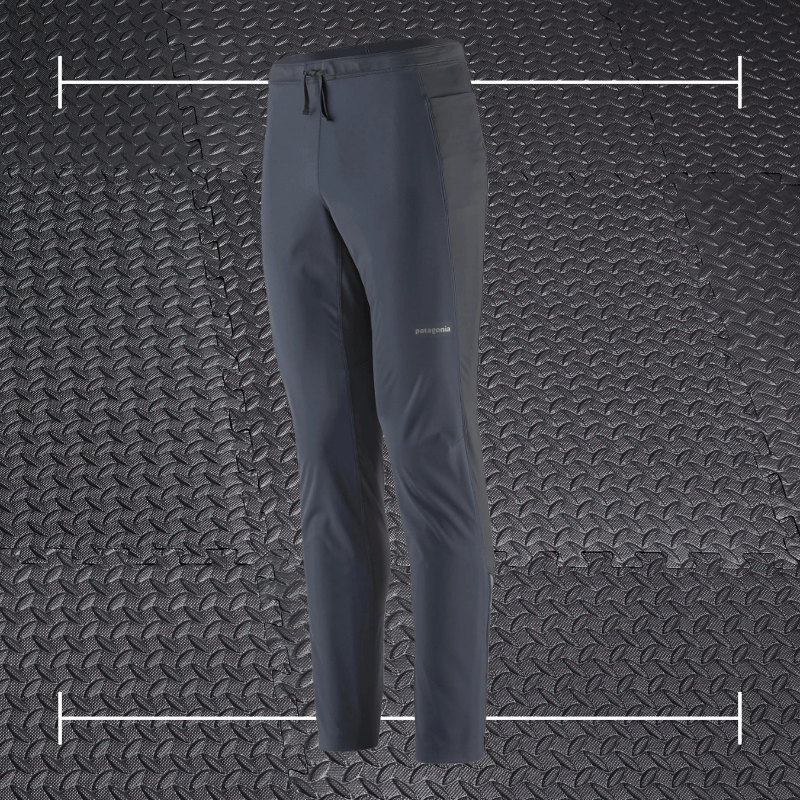 black patagonia pants laid on top a photo of black rubber gym flooring