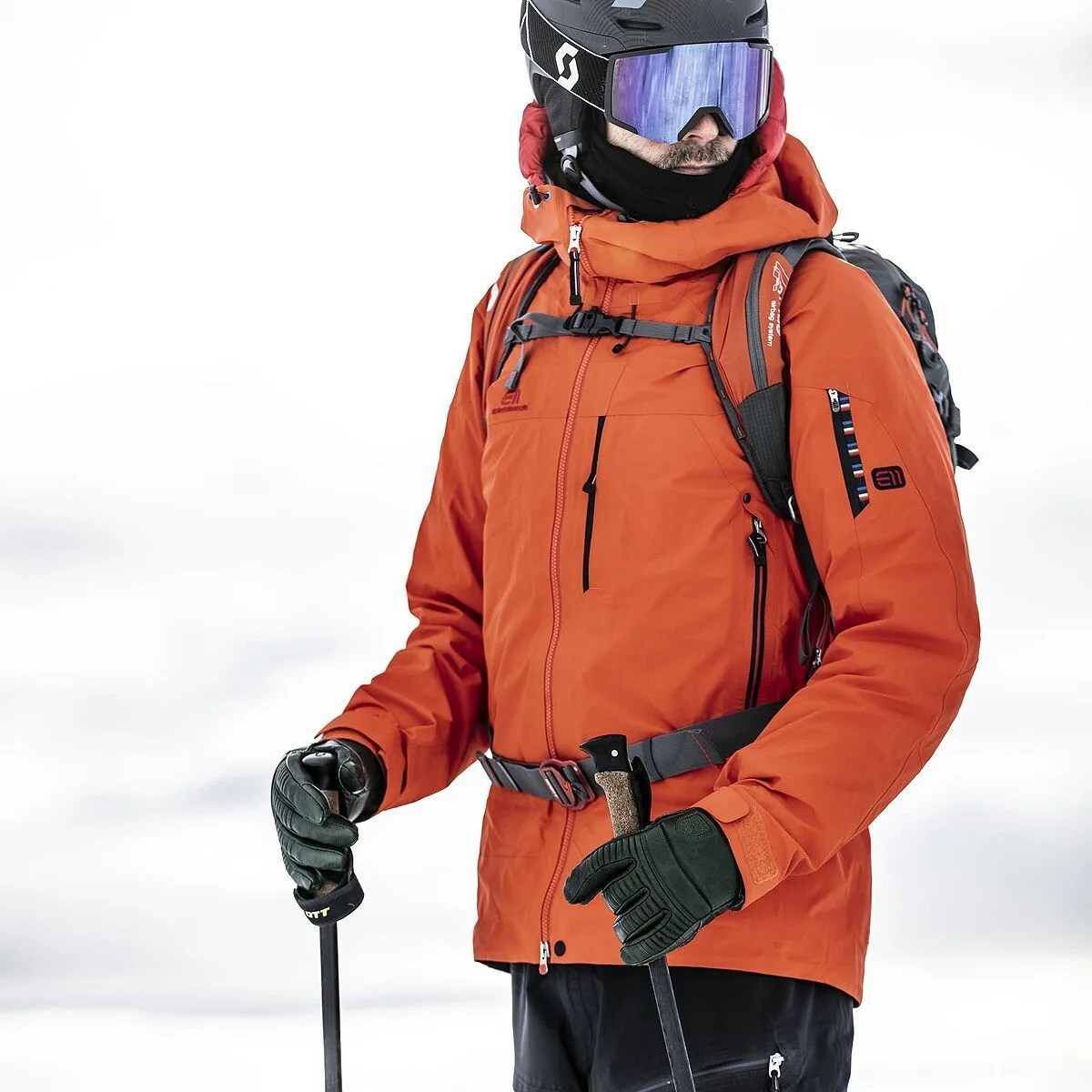 man wearing snow gear carrying ski poles