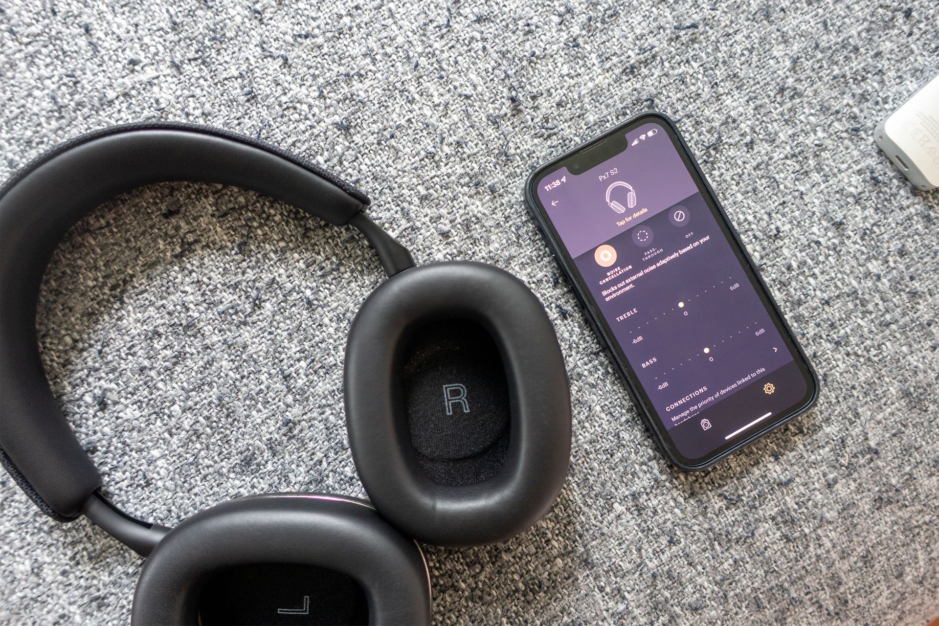 bowers and wilkins px7 s2 headphones nest to an iphone showing the music app