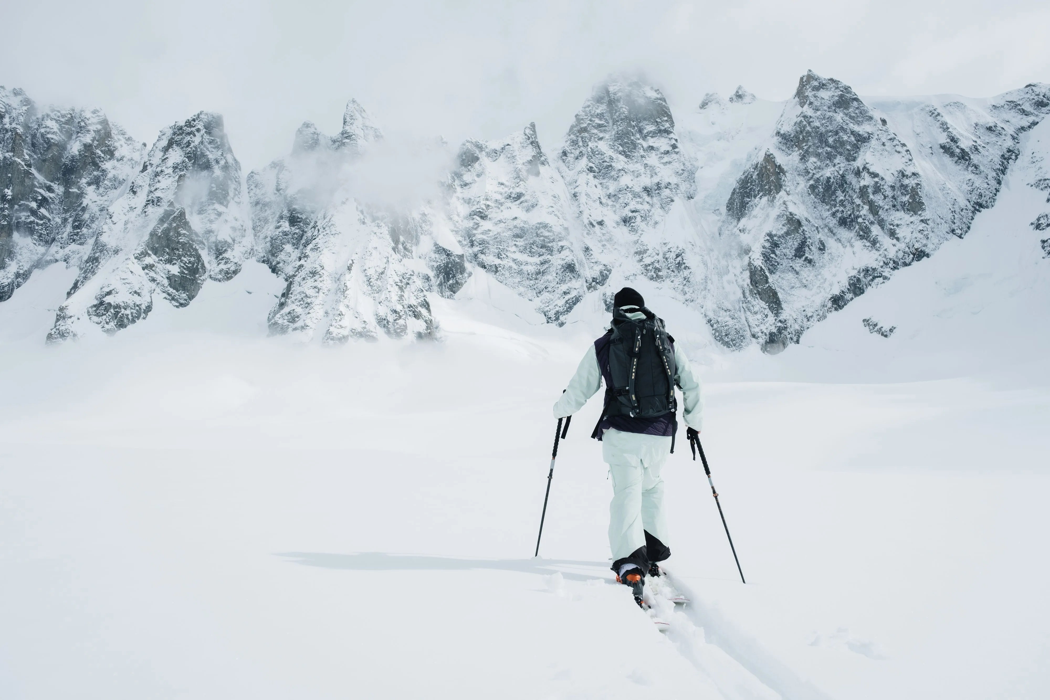 man trekking through snow wearing the fjäll 34l backpack