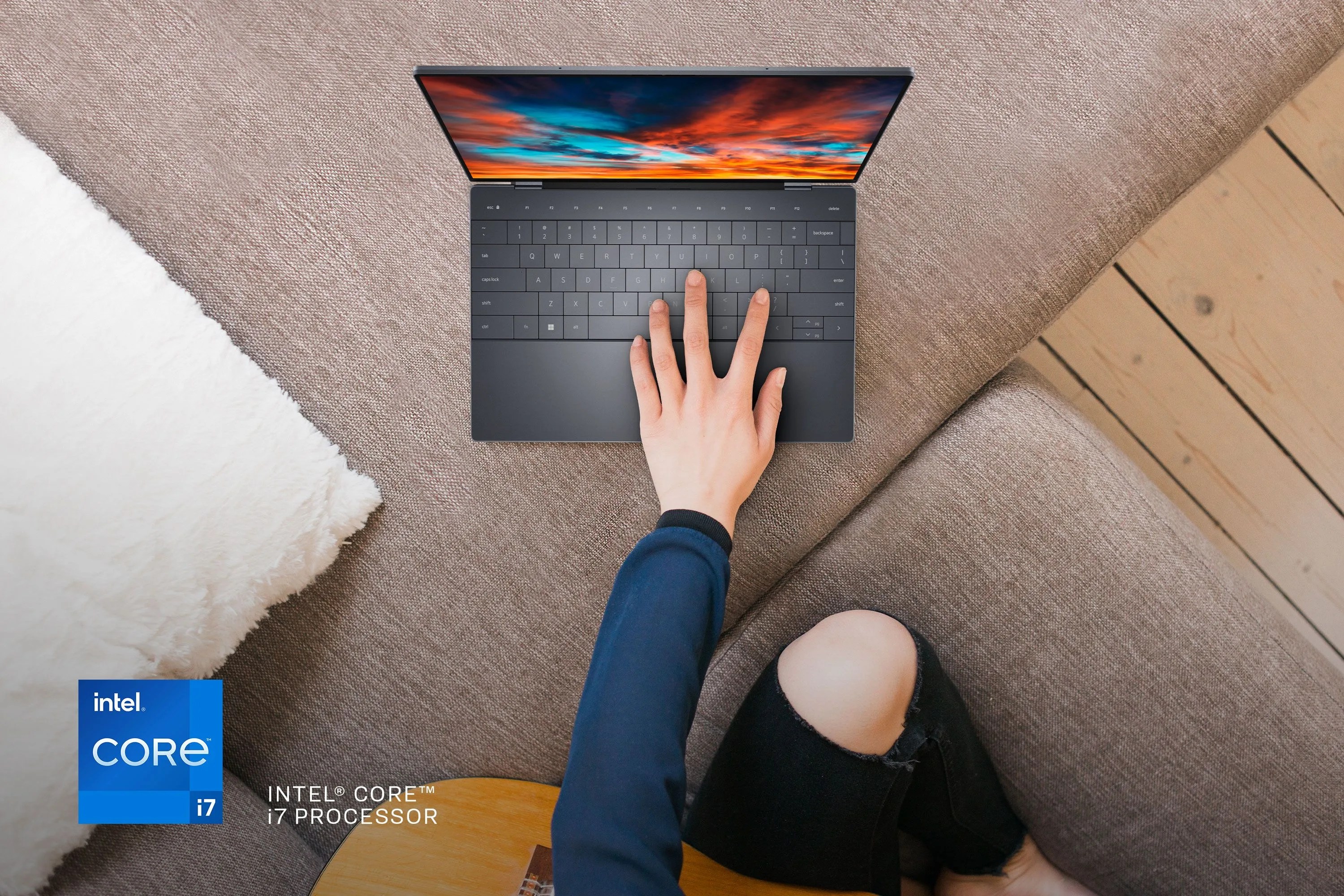 person holding guitar with one hand typing on dell laptop