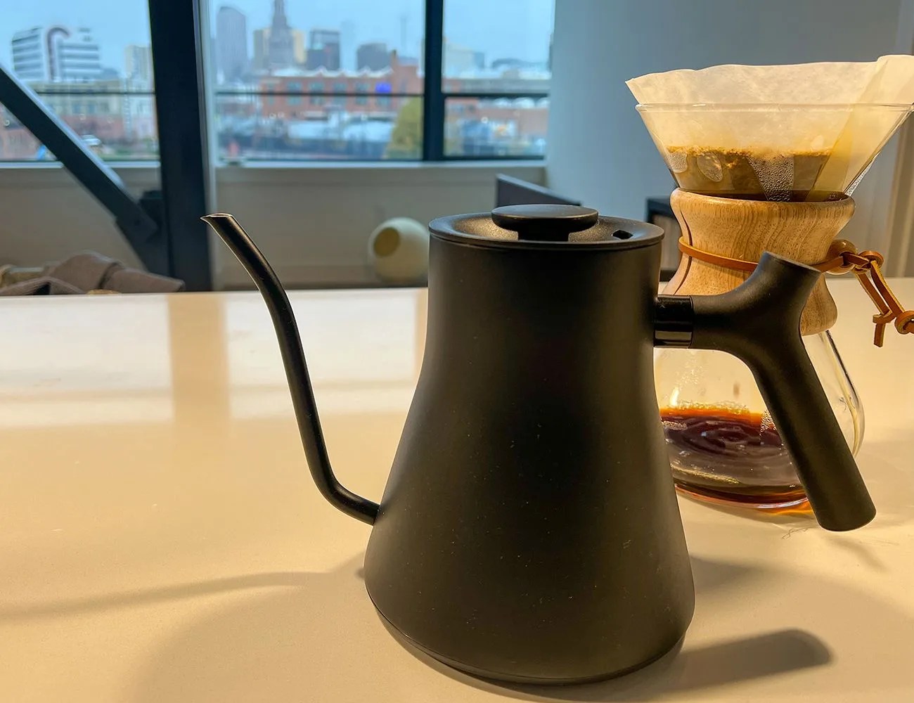fellow gooseneck kettle on a countertop next to pour over coffee