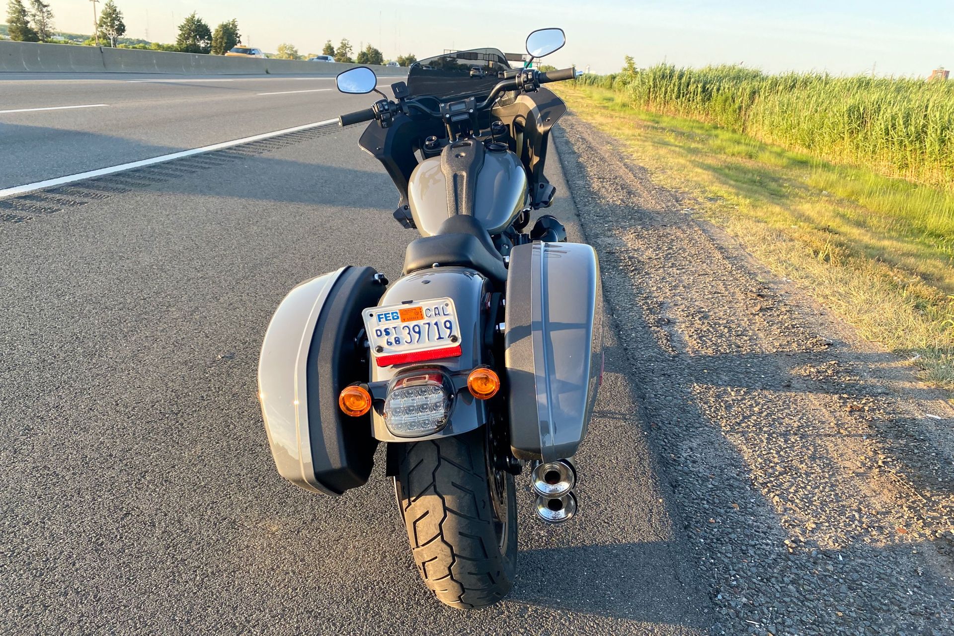 backside of the harley low rider st motorcycle parked on the side of the road