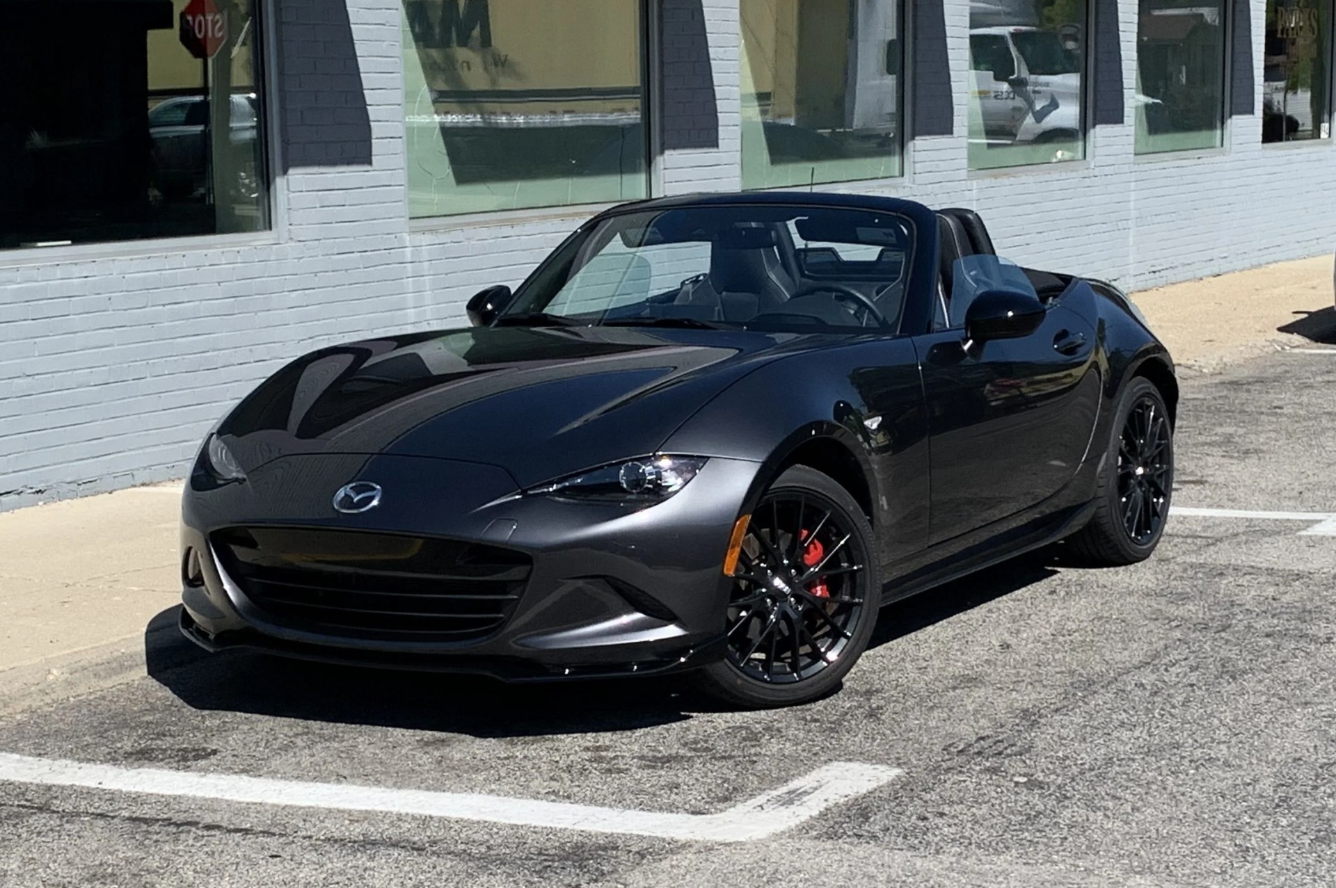 mazda mx 5 miata parked on the side of a street