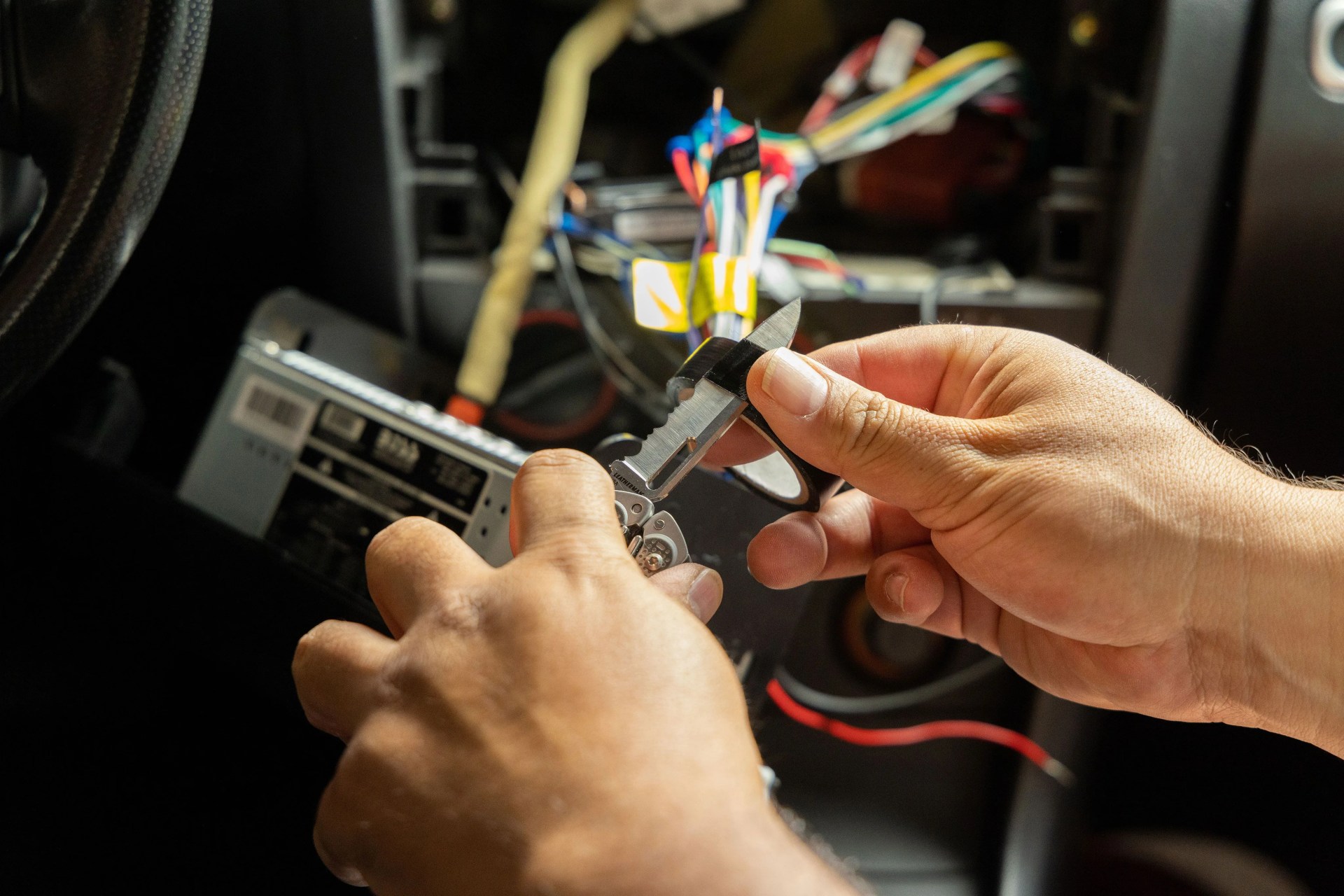 person using leatherman tool to cut electrical tape
