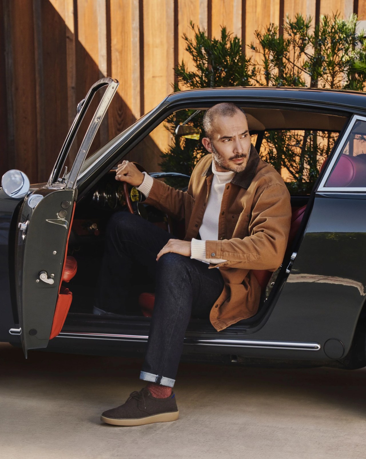 man sitting in car about to step out wearing rothy's the monty shoe