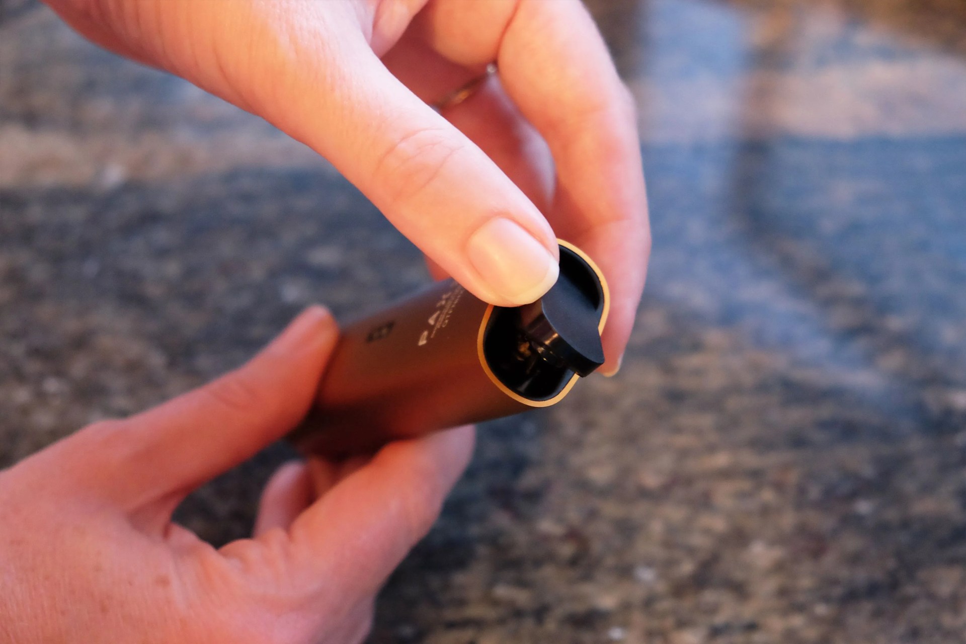 someone putting on the magnetic lid of the pax 3 vape