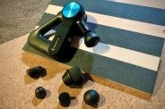 a therabody pro massage gun and extra massage heads sitting on a work out wedge and yoga mat