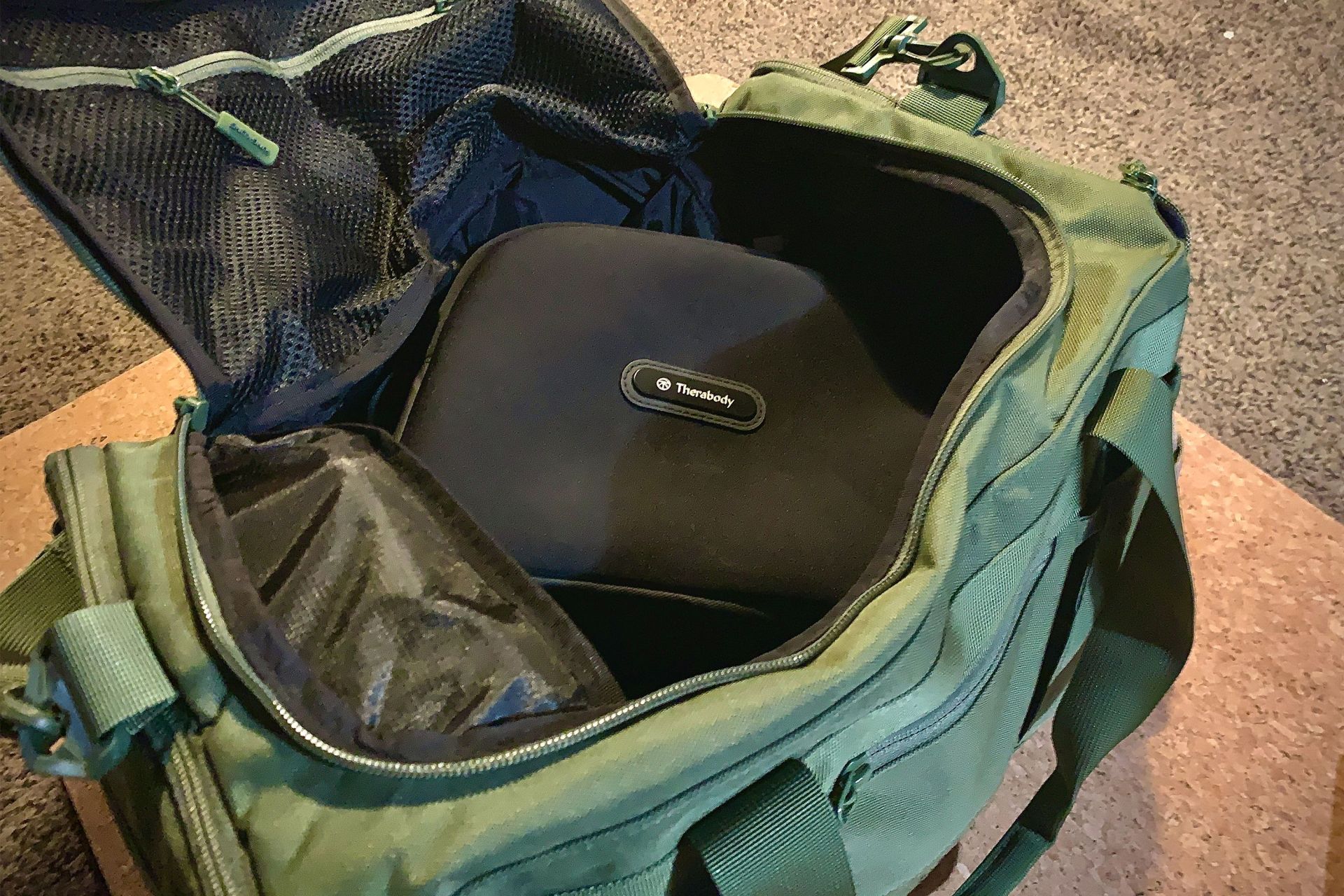 a therabody massage gun case in an open duffel bag